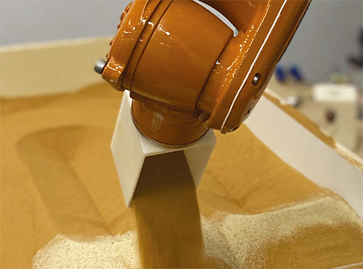 The robotic forming process performed
on the double-layered sandbox:  lifting, tilting, and pouring with tool.